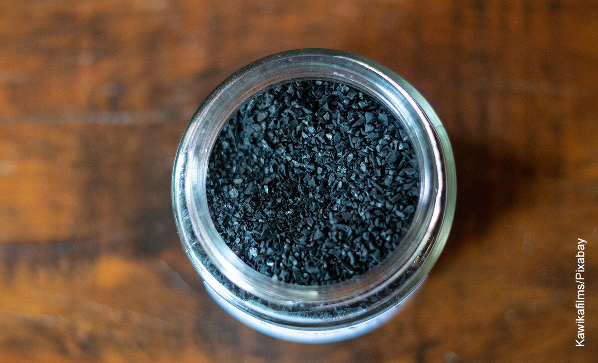 Foto de un tarro lleno de carbón que muestra para qué sirve el carbón activado
