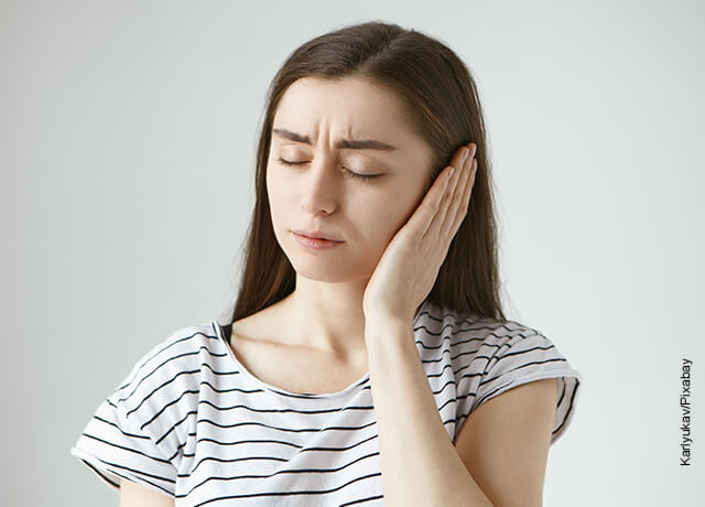 Foto de una mujer con evidente dolor de oído