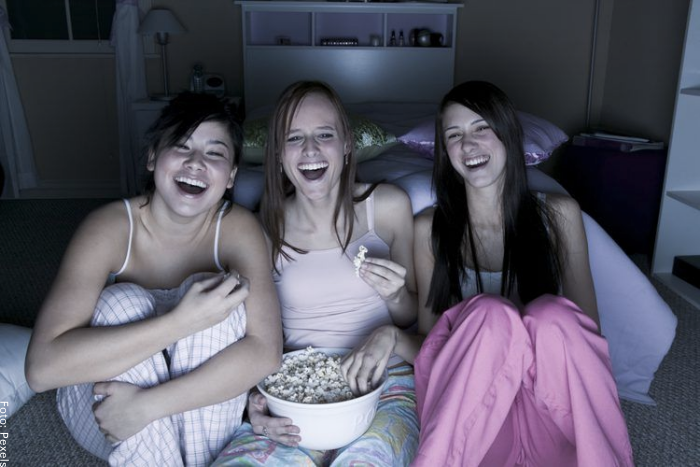 Foto de tres mujeres viendo una película con crispetas