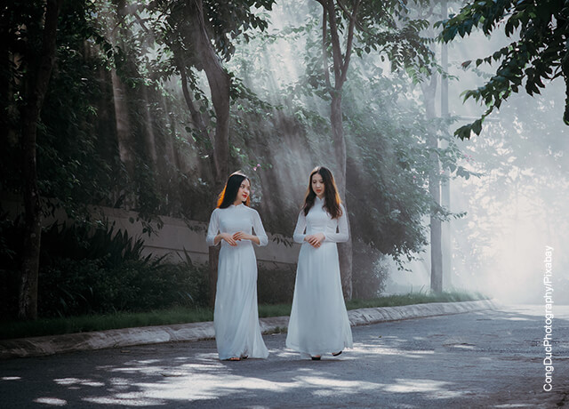 Foto de dos mujeres vestidas de blanco caminando