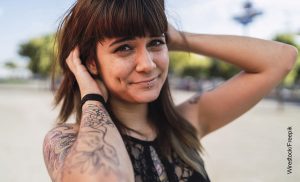 Foto de una mujer joven mostrando tatuajes en sus brazos que ilustra los tatuajes de animales