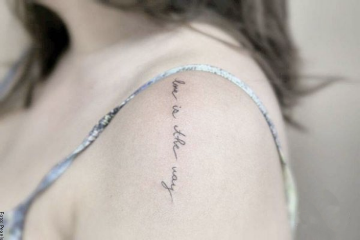 Foto de un tatuaje de frase en el hombro