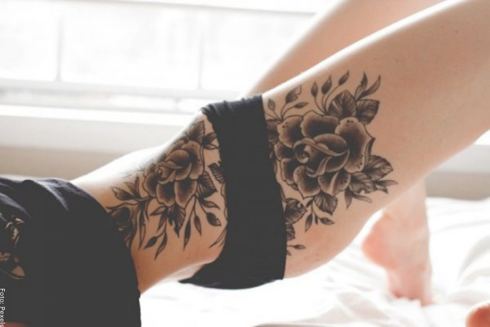 Foto de un tatuaje de rosas en la cintura y la pierna