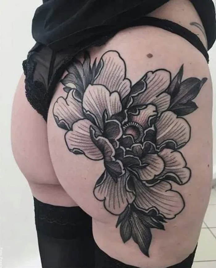 Foto de una mujer con tatuaje de flores en la cola