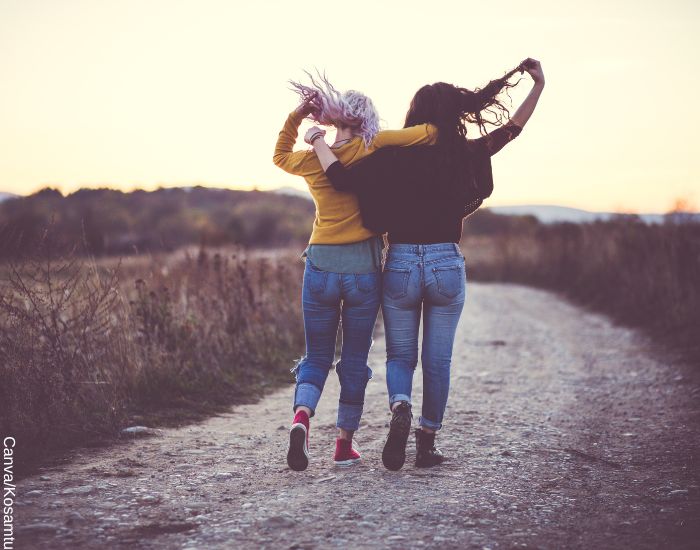Foto de dos hermanas abrazadas caminando en un atardecer de otoño