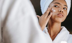 Foto de una mujer aplicando crema en su rostro que muestra el Acid Mantle para qué sirve
