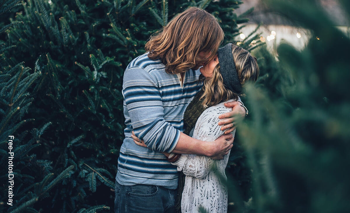 Foto de un hombre besando a una mujer en el parque que muestra cómo atraer a un hombre
