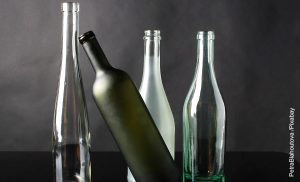 Foto de 4 envases sobre una mesa que muestra cómo decorar botellas de vidrio