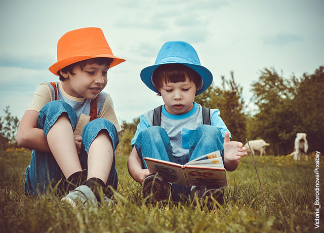 Foto de dos niños con un libro que muestra cómo enseñar a leer a un niño