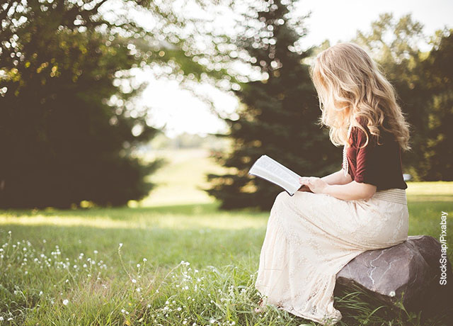 Foto de una niña leyendo en soledad en el parque