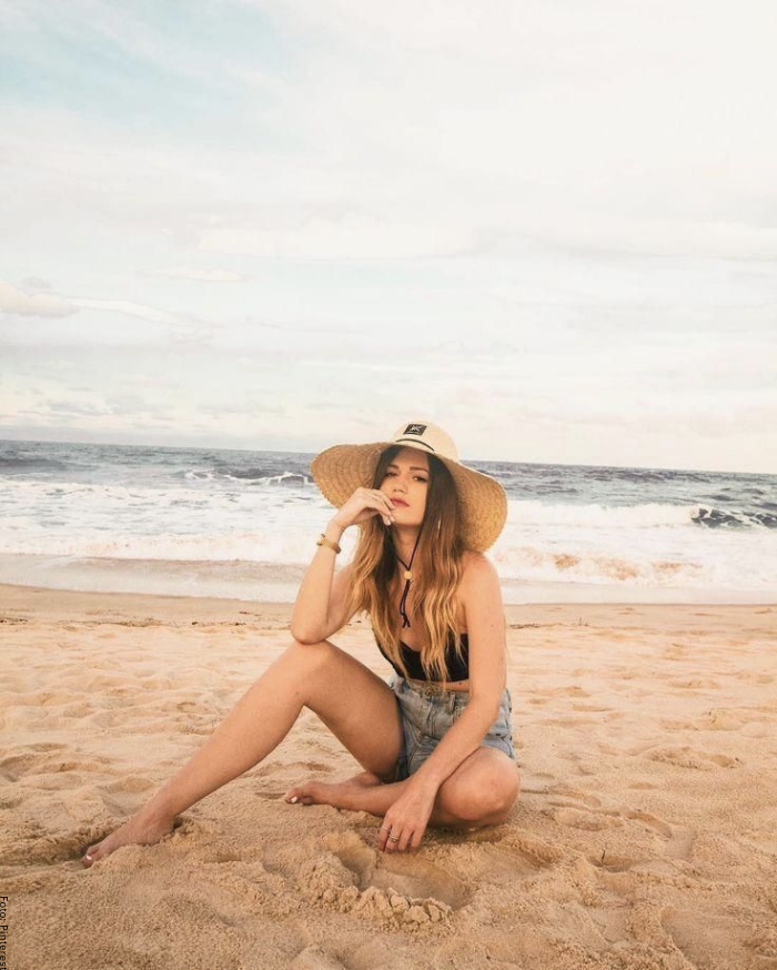 Foto de una mujer en la playa con sombrero