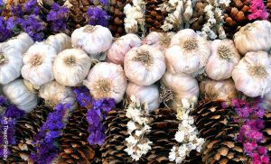 Foto de varios ajos en una canasta de madera con flores
