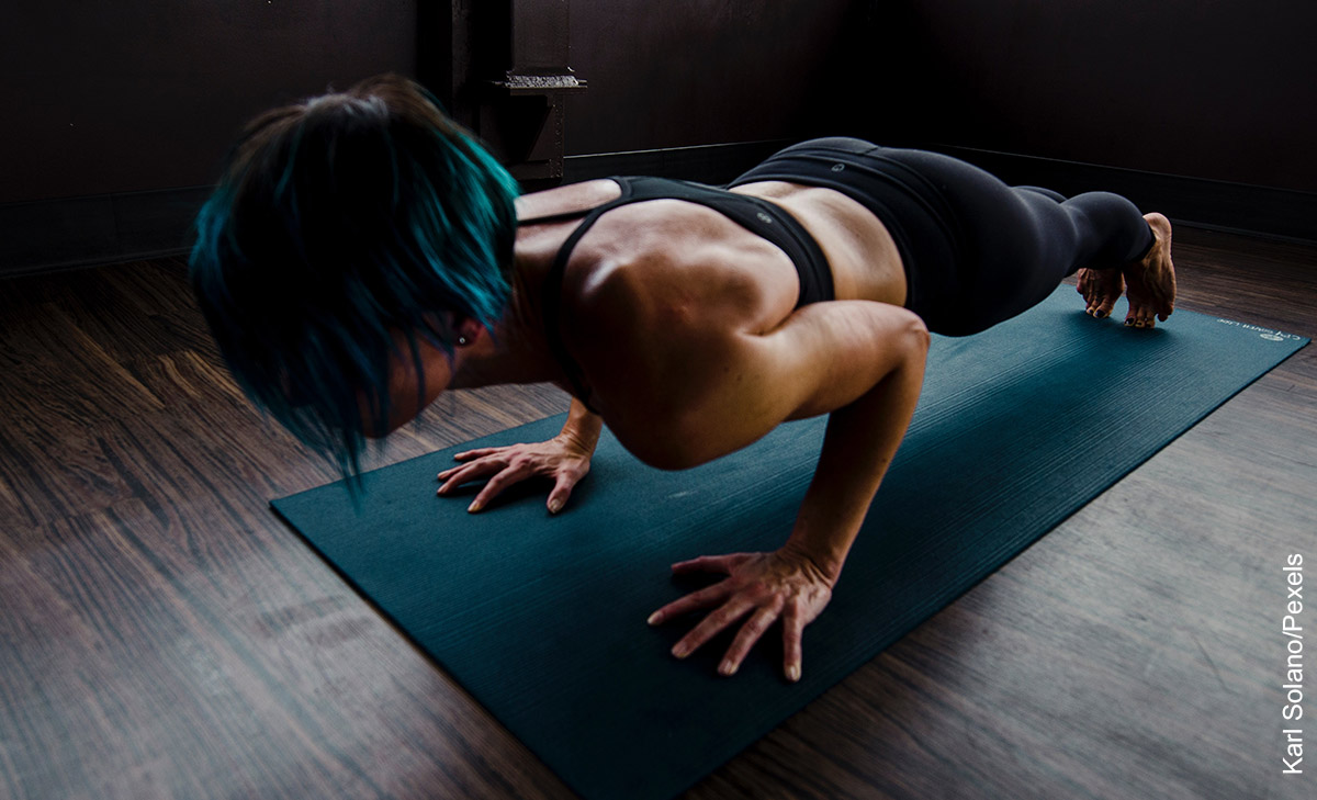 Foto de una mujer haciendo deporte sobre una colchoneta que ilustra los ejercicios para pecho en casa