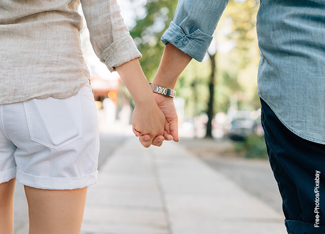 Foto de una pareja tomada de la mano en la calle que muestra qué significa soñar con una persona