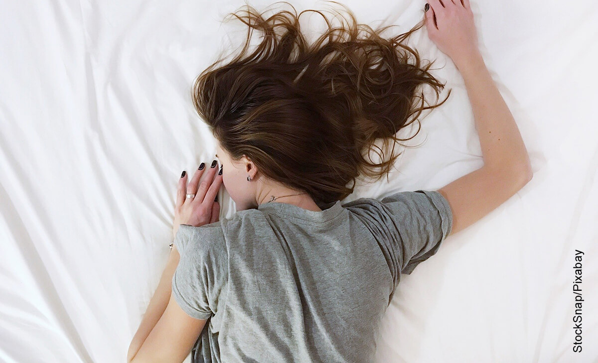 Foto de una mujer durmiendo boca abajo que muestra qué significa soñar con una persona