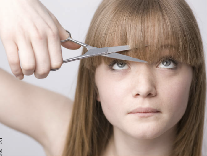 Foto de una mujer cortándose el cabello