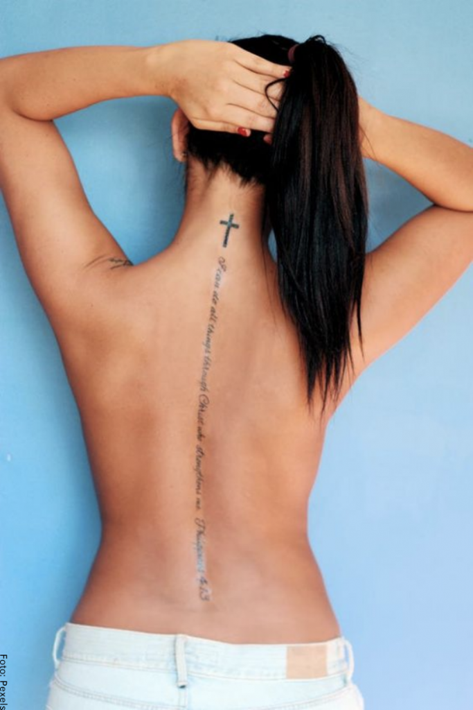Foto de una mujer con tatuaje de cruz en el cuello