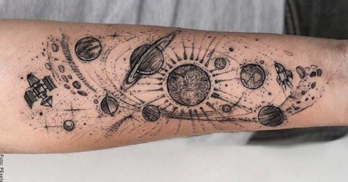 Foto de un tatuaje de varios planetas y galaxias