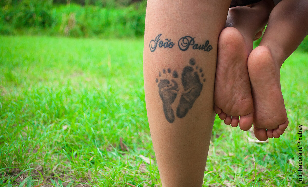 Foto de una mujer con un tatuaje en su pie, cargan a su bebé que ilustra los tatuajes para hijos