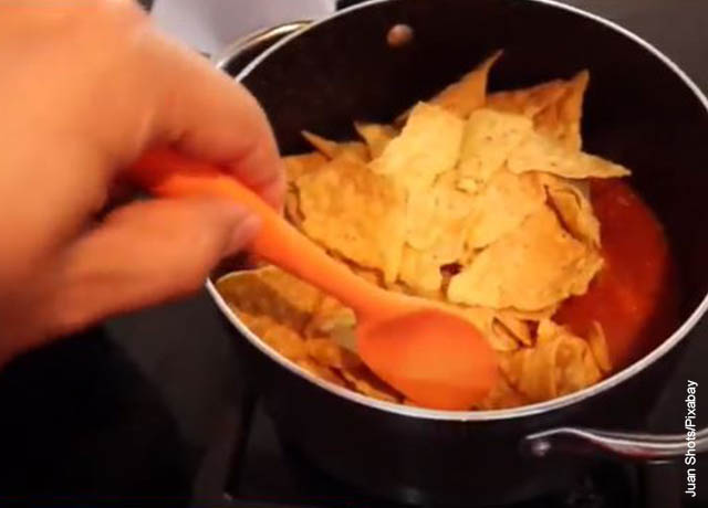 Foto de tortillas con salsa de tomate en una olla