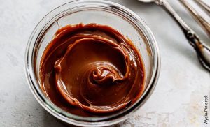 Foto de un recipiente con arequipe que muestra cómo hacer dulce de leche