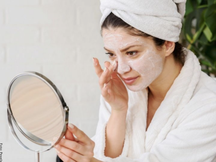 Foto de una mujer con mascarilla frente al espejo