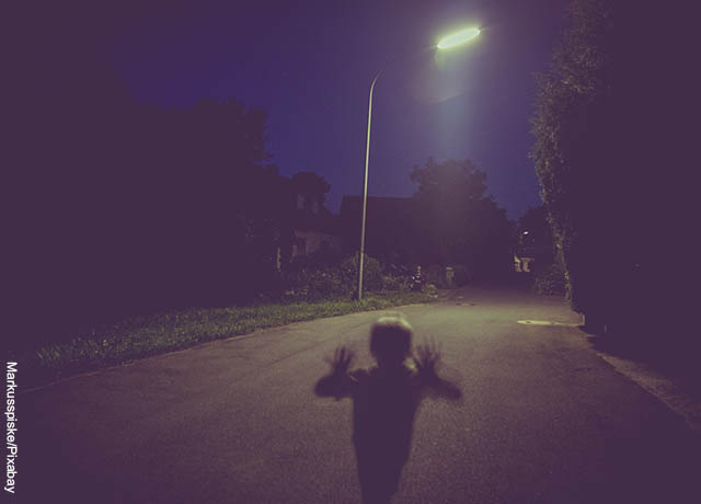 Foto de la sombra de un niño en la oscuridad en la calle