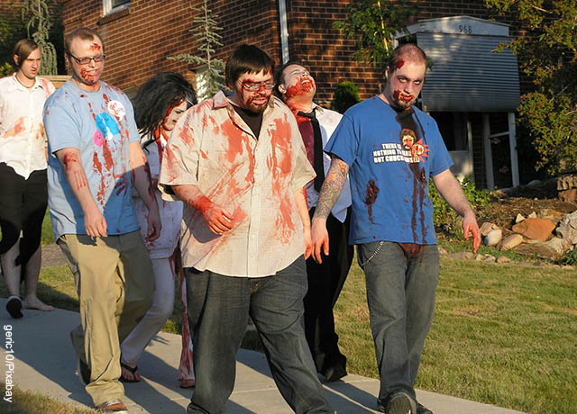 Foto de varios hombred caminando por la calle con disfraces que muestra qué significa soñar con zombies