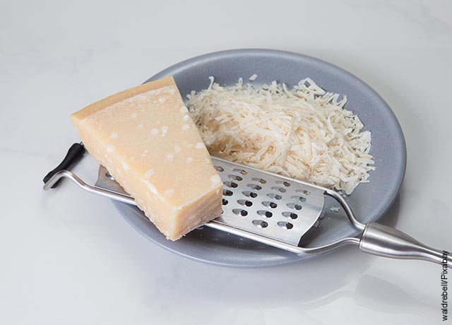 Foto de queso parmesano rayado sobre un plato gris