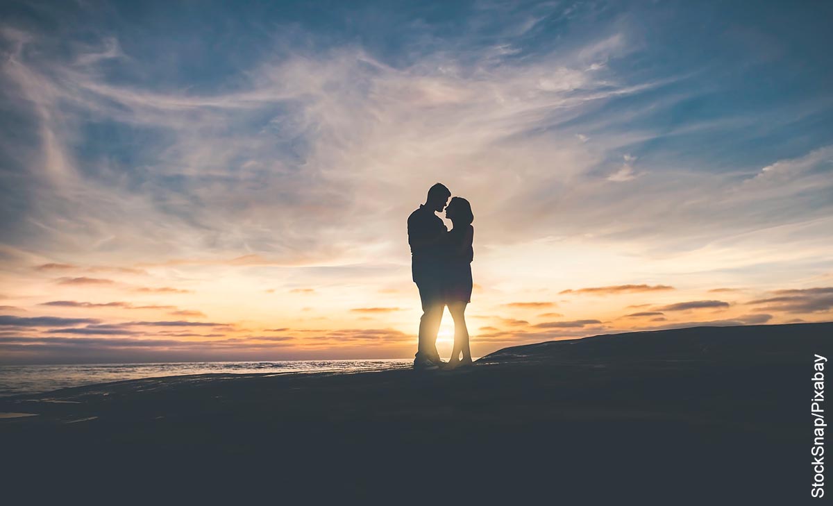 Foto de una pareja abrazada en la playa que muestra lo que es soñar con besar a un hombre