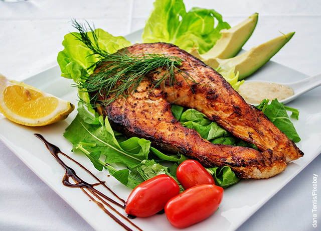 Foto de un pescado asado con verduras en un plato