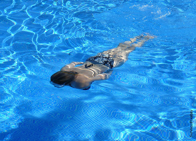 Foto de una mujer nadando debajo del agua que muestra lo que es soñar con piscina