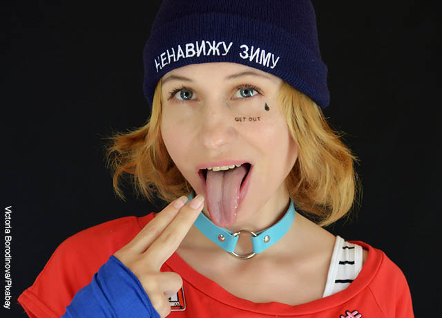 Foto de una joven llevando sus dedos a la boca en señal de vómito