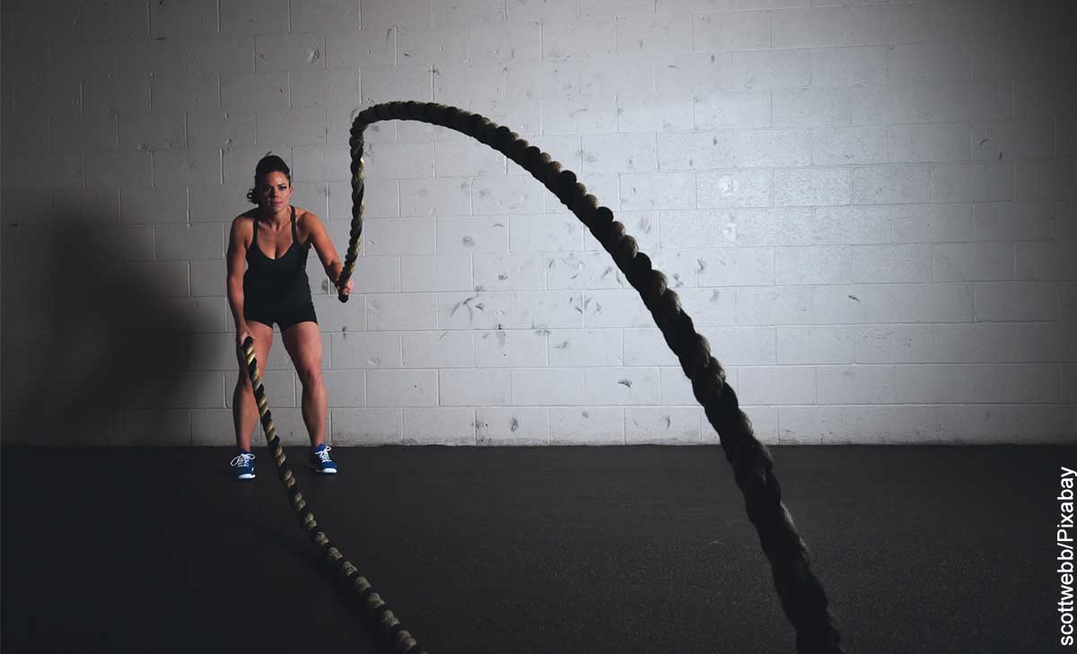 Foto de una mujer alzando unas cuerdas que muestra aq ué hora es mejor hacer ejercicio