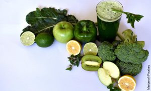 Foto de verduras, frutas junto con un vaso de jugo verde y su receta