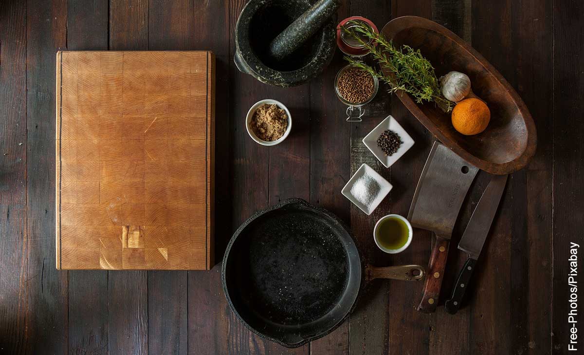 Foto de implementos de cocina y un libro sobre una mesa que muestra qué es una receta