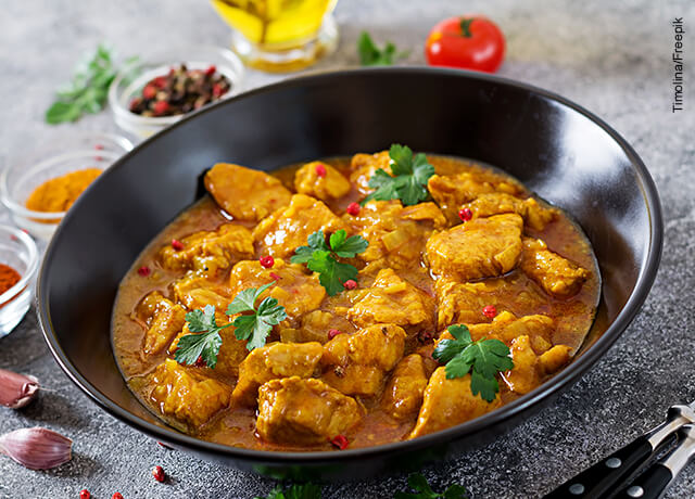 Foto de un plato negro con pollo al curry
