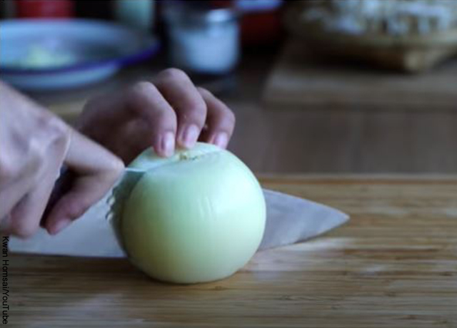 Foto de una persona cortando cebolla que revela el chop suey y su receta