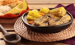 Foto de un plato de sopa en una vasija de barro que muestra cómo hacer un sancocho