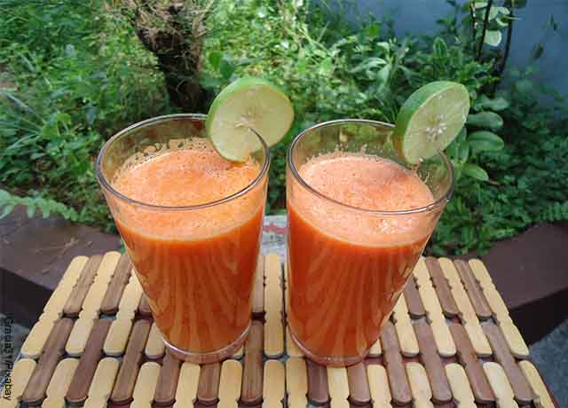 Foto de dos vasos de jugo de zanahoria con unas rodajas de limón