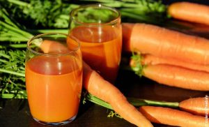 Foto de dos vasos de vidrio y varias zanahorias que muestra para qué sirve el jugo de zanahoria