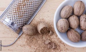 Foto de nueces ralladas sobre una mesa que muestra para qué sirve la nuez moscada