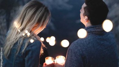 Foto de una pareja con velas en sus manos que muestra qué preguntas hacerle a un hombre