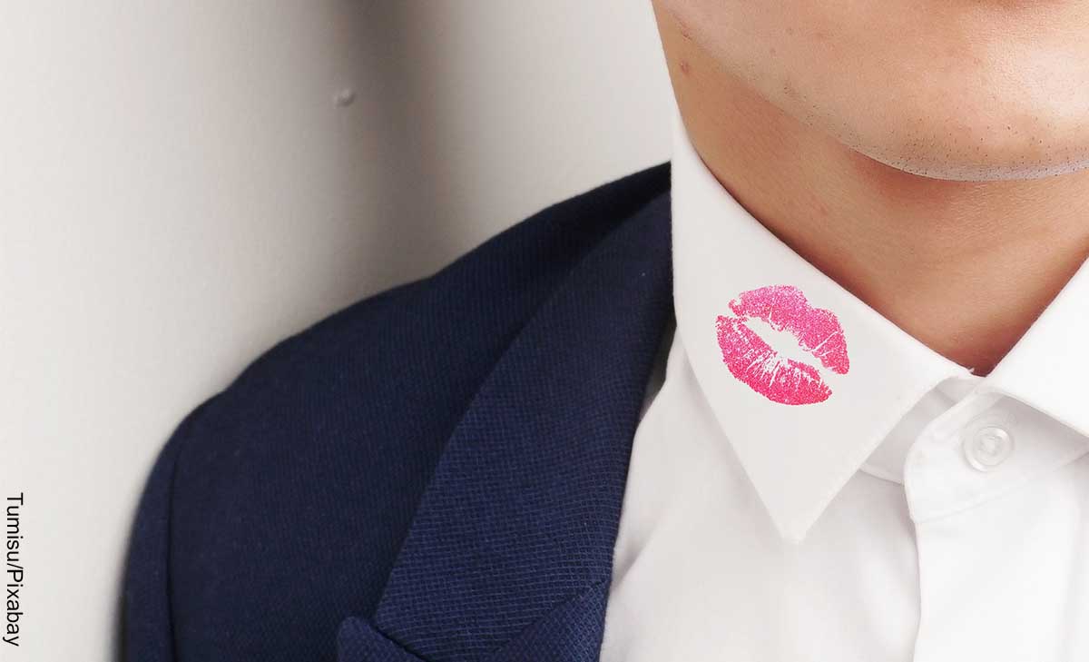 Foto del cuello de la camisa de un hombre con unos labios pintados que muestra qué significa soñar con infidelidad