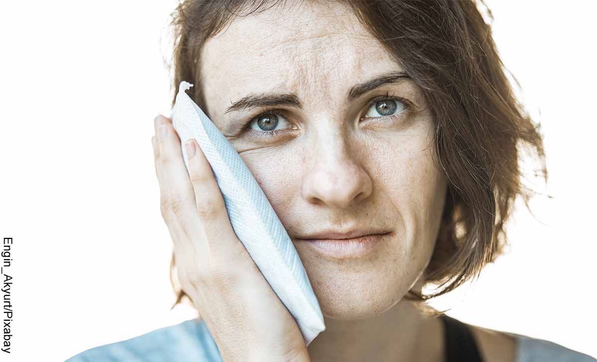 Foto de una mujer poniendo un paño en su cara que muestra qué sirve para el dolor de muela