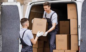 Foto de dos hombres descargando cajas de un camión que muestra lo que es soñar con trasteo