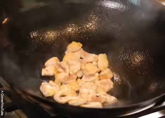 Foto de trozos de pollo en un wok