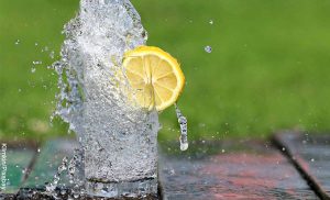Foto de un vaso de agua regándose de un vaso que revela para qué sirve el agua tibia con limón