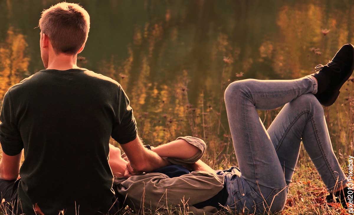 Foto de una pareja de novios sentados en un parque que revela lo que significa soñar con tu crush