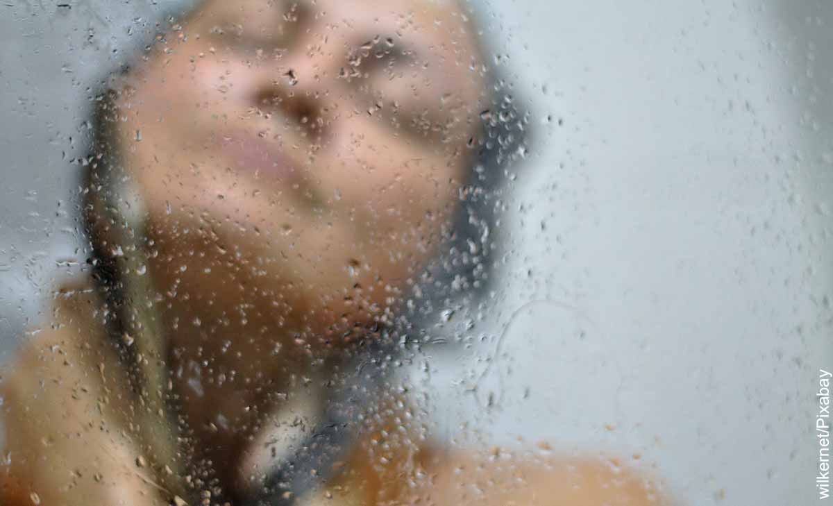Foto de una mujer tomando una ducha que revela lo que es soñar con bañarse
